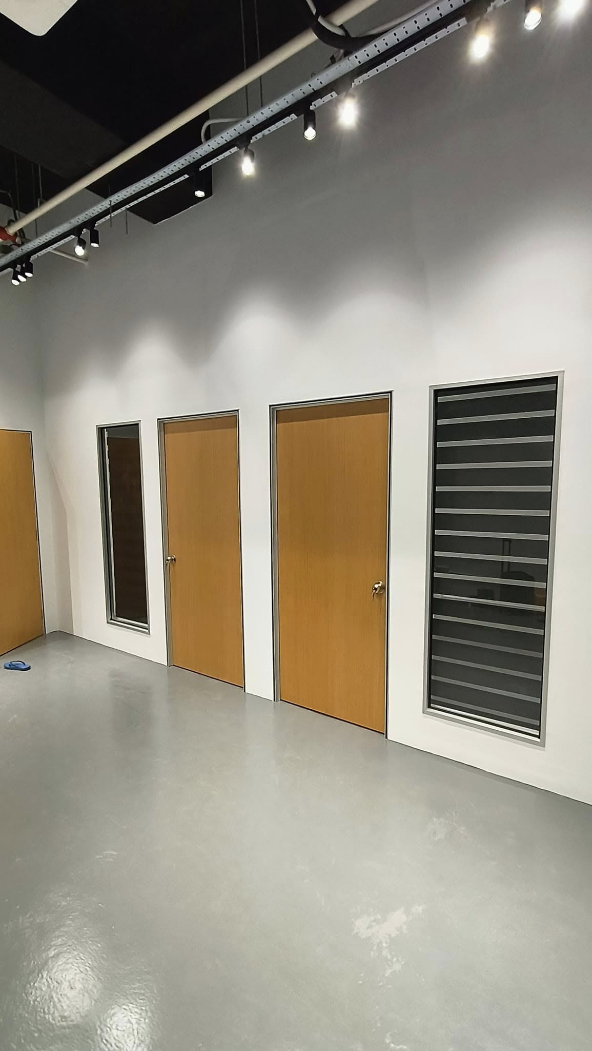 Row of partition rooms with timber doors and louvre window